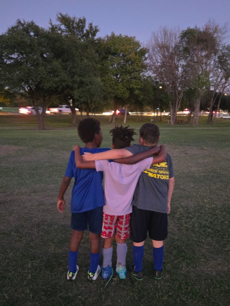 three youth soccer players standing together, a lesson in teaching kids about disappointment and teamwork